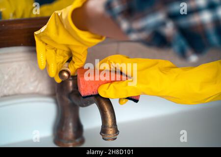 Mädchen in Gummihandschuhen ist Reinigung Badezimmer. Stockfoto