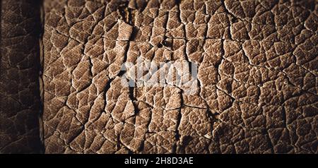 Fokussieren Sie das Stapelmakro aus gesprungenem Kunstleder auf Möbel mit sichtbaren Schäden. Stockfoto