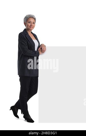 Reife asiatische Geschäftsfrau hält leeren Text Zeichen über weißem Hintergrund Stockfoto