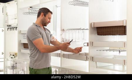 Lagerung und Arbeitsplätze Organisation in Küchenschrank. Der Käufer scannt den QR-Code mit einem Smartphone, um Küchenarmaturen und Möbel zu kaufen. Regale Stockfoto