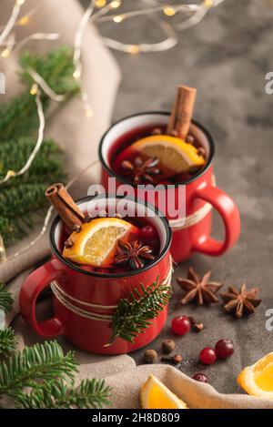 Glühwein in roten Tassen mit weihnachtlicher Dekoration Stockfoto