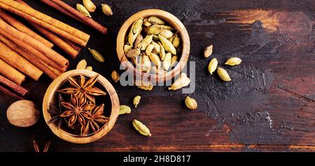 Set von Gewürzen aus Sternanise, Kardamom, Zimt und braunem Zucker auf altem Holzhintergrund. Flach liegend. Stockfoto