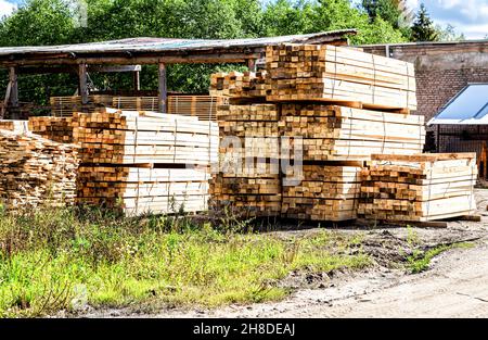 Schnittholz im Sägewerk. Gesägte und verarbeitete Hölzer im Lager, Holzstapel im Werkshof. Stapel von Holzbrettern im Lager. Schnittholz wird am gelagert Stockfoto
