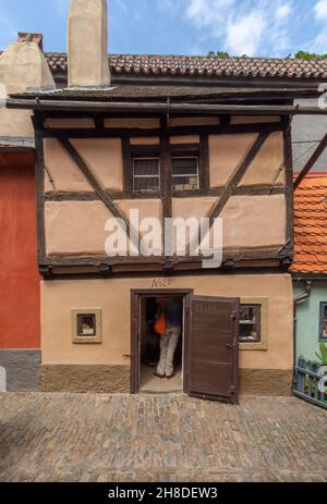 Das Goldene Gässchen Nr. 20 in der mittelalterlichen Straße der Prager Burg, das sich in einem alarmierenden Winkel neigt, beherbergt heute ein Geschäft, in dem alte Musikinstrumente und Noten verkauft werden Stockfoto