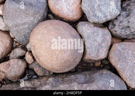 Steine in verschiedenen Größen an der Küste. Hintergrund. Draufsicht. Stockfoto