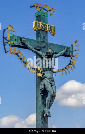 Das Kruzifix von H. Hillger aus dem Jahr 1629 und die Kalvarienstatuar auf der Karlsbrücke.der goldene hebräische Text auf dem Kruzifix wurde 1696 hinzugefügt Stockfoto