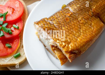 Geräucherter Weißfisch auf einem Teller mit Tomaten-Sandwich Stockfoto