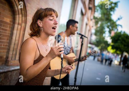 Straßenmusiker, die auf einer belebten Straße in Sevilla, Spanien, spielen. Nahaufnahme Stockfoto