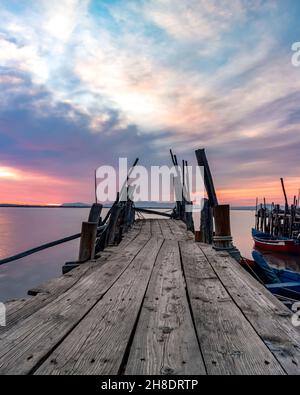 Spektakulärer Sonnenuntergang am Carrasqueira Palafitic Pier in Comporta, Portugal. Hochformat Stockfoto