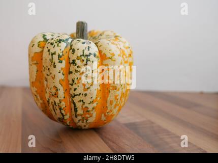 Wunderschön gefärbtes Squashgemüse in Orange und Grün auf dem Tisch Stockfoto