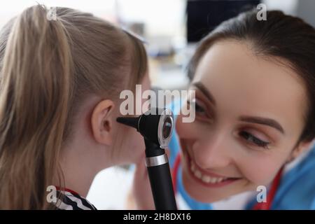 HNO-Frau untersucht das Ohr eines kleinen Mädchens mit Otoskop in der Klinik Stockfoto