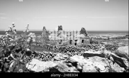 Schwarz-Weiß-Aufnahme eines verlassenen, ruinierten Häuschens auf Inishmaan (Inis Meain), einer der Aran-Inseln vor der Küste von Galway im Westen Irlands. Stockfoto