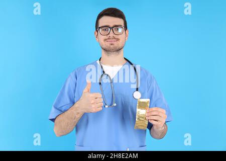 Praktikant Arzt hält Kondome auf blauem Hintergrund Stockfoto