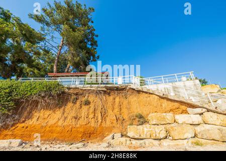 Schöne Aussicht auf das Haus mit weißem Metallzaun am Klippenrand. Griechenland. Stockfoto