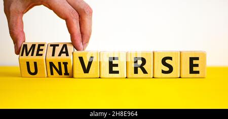 Universum oder Metaverse Symbol. Geschäftsmann dreht Holzwürfel und ändert das Wort Universum zu Metaverse. Schöne gelbe Tabelle weißen Hintergrund, Kopie Stockfoto