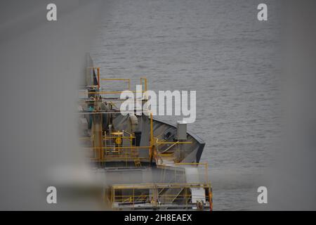 Blick von unscharfem Vordergrund auf den vorderen Steuerbordteil des Containerschiffes des Händlers. Stockfoto