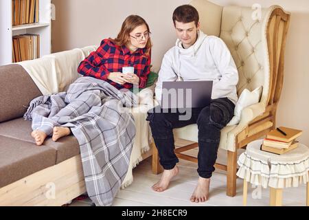 Ein IT-Spezialist richtet einen Laptop für die Arbeit von zu Hause aus ein und richtet einen Remote-Desktop für Mitarbeiter des Unternehmens ein. Stockfoto