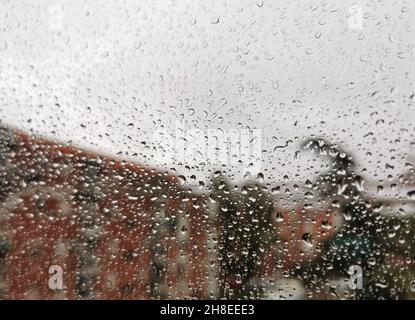Glasfenster mit vielen Regentropfen darauf Stockfoto