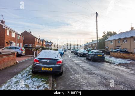 Ein Blick auf eine Wohnstraße in Tilehurst, Reading, Großbritannien, an einem Wintermorgen mit einer leichten Schneedecke aus der Nacht zuvor. Stockfoto