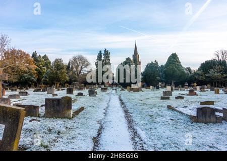 Blick auf den Friedhof in der St. Michaelskirche in Tilehurst Reading an einem Wintertag mit einer leichten Schneedecke. Stockfoto