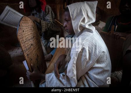 Der junge Mann in einer Koranschule sitzt vor Holztafeln und rezitiert Stunden für Stunde Tag in Timbuktu, Mali, Westafrika, koranische Verse. Stockfoto