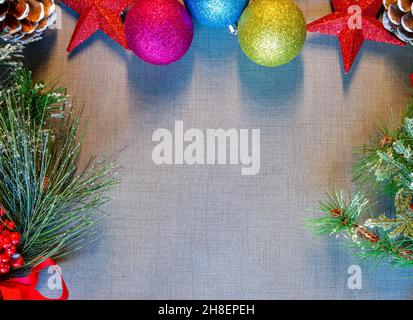 Chirstmas-Baumkugeln, die auf dem Tischset mit Pinienzapfen und Kiefernzweigen auf dem Bild ausgerichtet sind Stockfoto