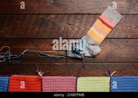 Hintergrundbild von bunten Strick Socken auf dunklem Holzhintergrund, Stricken und Hobby, kopieren Raum Stockfoto