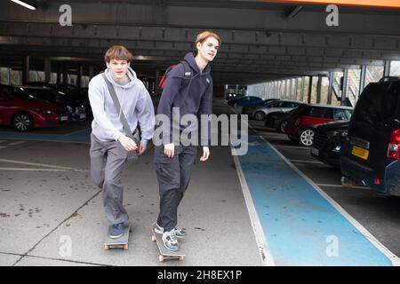 Teenager-Jungen Skateboarding auf dem Parkplatz Stockfoto