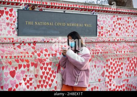 London, Großbritannien. 29th. November 2021. Eine Dame, die eine Gesichtsmask trägt, als vorbeugende Maßnahme gegen die Ausbreitung von Covid-19-Spaziergängen entlang der National Covid Memorial Wall in Westminster, London, wurden weitere 42.583 neue Covid19 Fälle sowie 35 Todesfälle in den neuesten Zahlen der Tageszeitung Covid19 verzeichnet. (Bild: © Pietro Recchia/SOPA Images via ZUMA Press Wire) Stockfoto