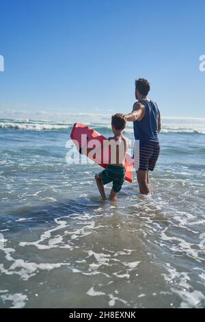 Vater und Sohn mit Body Board im sonnigen Sommermeer Stockfoto