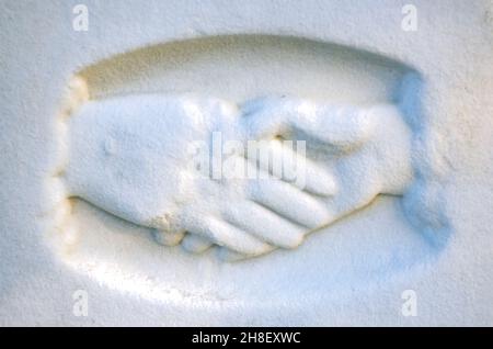 Verschlagene Hände sind auf einem Grabstein auf dem Magnolia Cemetery, 26. November 2021, in Mobile, Alabama, abgebildet. Die verschlammten Hände symbolisieren typischerweise einen Abschied. Stockfoto