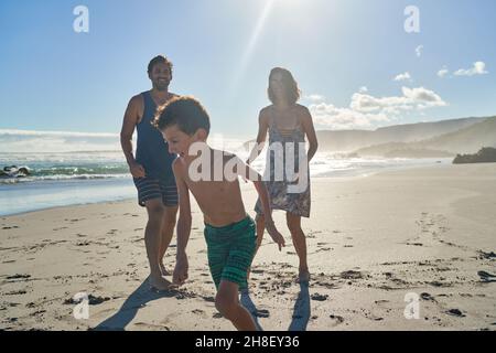 Glückliche Familie spielt am sonnigen Sommerstrand Stockfoto