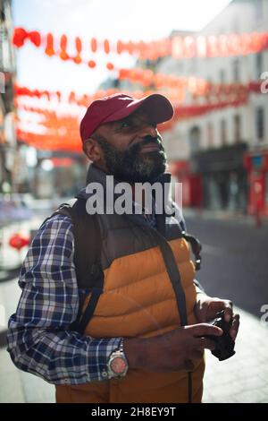 Reifer männlicher Tourist auf der sonnigen Stadtstraße Stockfoto