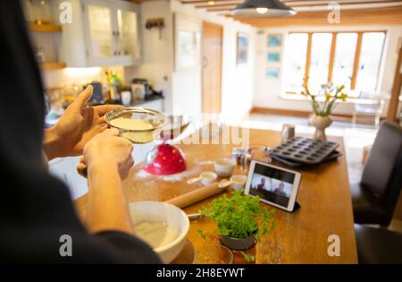 Mann Video chatten und frischen Pizzateig in der Küche zu machen Stockfoto