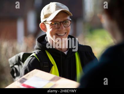 Freundlicher männlicher Kurier, der das Paket liefert Stockfoto