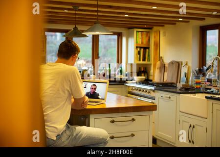 Mann Videokonferenzen mit Kollegen am Laptop in der Küche Stockfoto