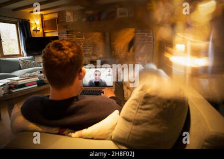 Mann Videokonferenzen mit Kollegen auf Laptop auf dem Sofa Stockfoto