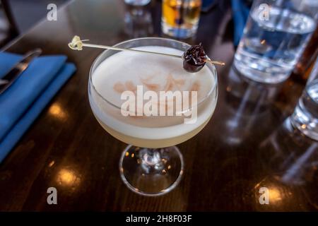 Blick von oben auf einen frisch zubereiteten Whiskey Sour auf dem Holztisch eines Restaurants Stockfoto