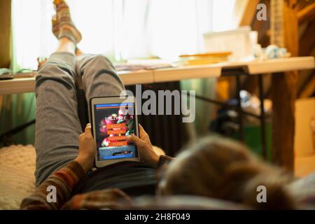 Legere Frau in Jogginghosen, die Essen zum Mitnehmen auf einem digitalen Tablet bestellt Stockfoto