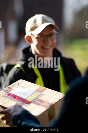 Freundlicher männlicher Kurier, der das Paket vor der Tür lieferte Stockfoto