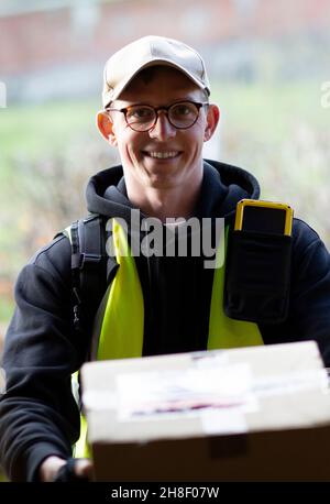 Portrait freundlicher männlicher Kurier, der Paket liefert Stockfoto