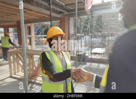 Architekt und Vorfrau schüttelten sich auf der Baustelle die Hände Stockfoto