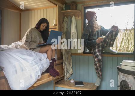 Paar entspannen sich und benutzen einen Laptop in einer winzigen Hütte Stockfoto