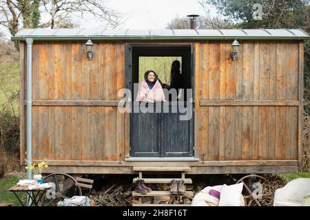 Sorglose junge Frau in einem winzigen Fenster zur Vermietung von Hütten Stockfoto