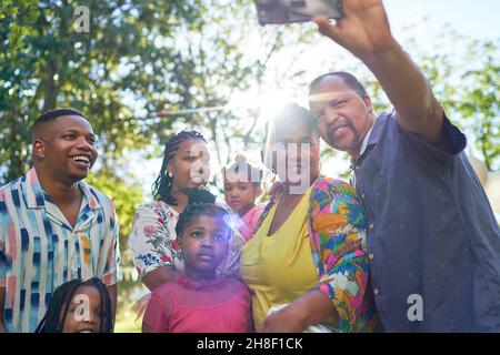 Glückliche Familie mit mehreren Generationen, die Selfie im sonnigen Park macht Stockfoto