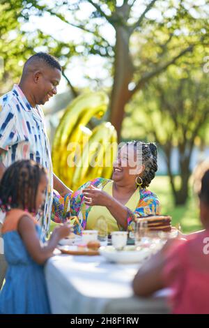 Eine glückliche Familie mit mehreren Generationen, die am Tisch auf der Terrasse Geburtstag feiern kann Stockfoto