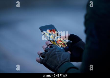 Nahaufnahme Mann bestellt Essen zum Mitnehmen mit dem Smartphone Stockfoto