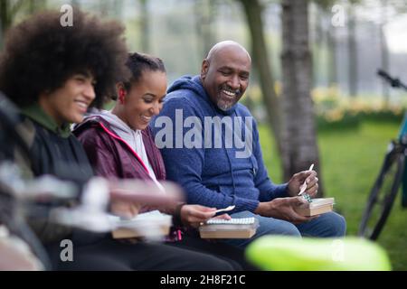 Fröhlicher Vater und Teenager, die im Park zu Mittag essen Stockfoto