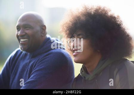 Glücklicher Vater und jugendlicher Sohn schauen weg Stockfoto