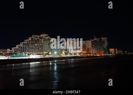 Nächtliche Skyline von Daytonas Beach, Florida, fotografiert vom Angelpier. Langzeitbelichtung mit Hotels, Strand und Wellen. Stockfoto